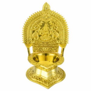 A large brass Kamatchi vilakku (lamp) with intricate traditional design, polished to a shine.