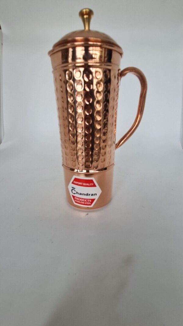 Handcrafted copper hammered water jug with traditional design.