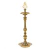 A traditional brass Kuthu Vilakku (lamp) with intricate designs, used for religious and decorative purposes.